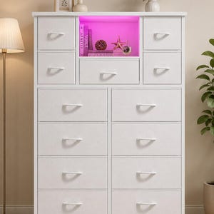 May include: A white storage dresser featuring twelve fabric drawers with white handles and a central open shelf illuminated by pink LED lighting. The unit has a rectangular frame with a flat top surface and a power cord extending from the base.
