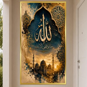 May include: A rectangular wall art piece in a gold frame featuring gold Arabic calligraphy of Allah and the phrase "Wa ma tawfiqi illa billah" set against a dark blue and gold textured background with a silhouette of a mosque at sunset.