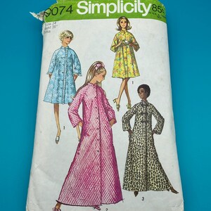 Puede incluir: Un sobre de patrón de costura Simplicity, número 9074, con ilustraciones de cuatro estilos diferentes de batas. Los diseños incluyen una bata azul con flores, una amarilla con flores, una bata larga acolchada rosa y una bata larga con estampado de leopardo.