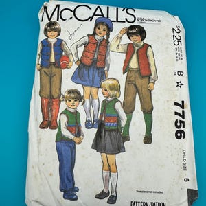 Può includere: Una busta per cartamodello McCall's bianca, numero 7756, per taglia bambino 5. Il fronte presenta illustrazioni di bambini che indossano gilet, camicie, pantaloni e gonne. Il testo include 'McCall's', '7756', 'CHILD SIZE 5' e 'Sweaters not included'.