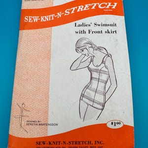 Pode incluir: Um envelope de molde de costura vintage para um fato de banho com saia frontal, intitulado SEW-KNIT-N-STRETCH. A embalagem branca e laranja apresenta um desenho de um fato de banho, o texto DESIGNED BY: KERSTIN MARTENSSON e o tamanho 14-16-18.