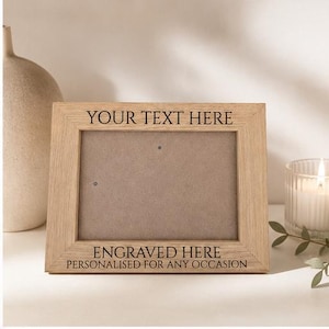 May include: A rectangular light brown wooden photo frame with a visible grain texture. The top border is engraved with the text YOUR TEXT HERE, and the bottom border features the text ENGRAVED HERE and PERSONALISED FOR ANY OCCASION.