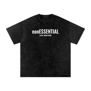 May include: A black acid-wash t-shirt with a crew neckline and short sleeves. The chest features white printed text that reads nonESSENTIAL in a bold font, with the words I JUST WORK HERE printed in a smaller, simpler font directly below it.