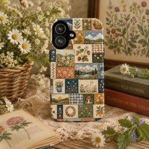 May include: A rectangular phone case featuring a patchwork design of various nature-themed illustrations, including mountains, a lake, a duck, strawberries, flowers, a mushroom, and carrots, all rendered in a textured, woven fabric-like pattern.