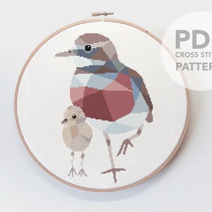 Peut inclure: Modèle de point de croix avec un motif géométrique d'une mère oiseau et de son petit. Les oiseaux sont dans des tons de brun, bleu et rose.