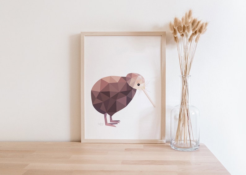 Peut inclure: Impression encadr&eacute;e d'un kiwi g&eacute;om&eacute;trique dans des tons bruns et roses. L'&oelig;uvre est pos&eacute;e sur une surface en bois clair, avec un vase en verre transparent contenant des fleurs s&eacute;ch&eacute;es &agrave; droite.