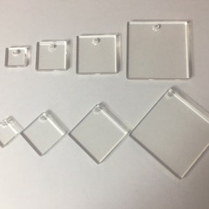 May include: A collection of clear acrylic square and diamond shapes in various sizes. Each shape has a small hole at the top for hanging. The sizes vary from approximately 1 inch to 4 inches.