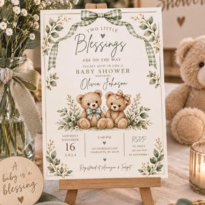 May include: A rectangular baby shower invitation card featuring two illustrated teddy bears, green gingham ribbon accents, and botanical leaf motifs. The text reads: Two Little Blessings Are On The Way, Please Join Us For A Baby Shower Honoring Olivia Johnson.