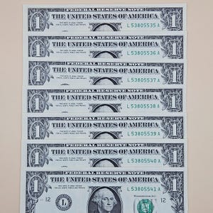 May include: A stack of seven sequential one-dollar Federal Reserve Notes. Each bill features the text THE UNITED STATES OF AMERICA and serial numbers ranging from L 53805535 A to L 53805541 A. The bills are printed in black and green ink on white paper.