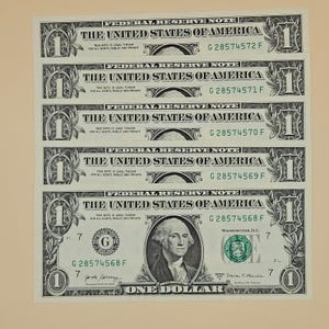 Pode incluir: Cinco notas de um dólar empilhadas verticalmente, cada uma com o texto Federal Reserve Note, The United States of America e One Dollar. As notas exibem números de série sequenciais de G28574568F a G28574572F, com o retrato de George Washington.