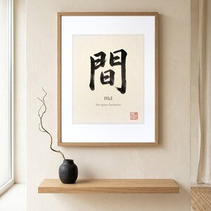 Framed "Ma" calligraphy artwork in a bright neutral living room featuring clean, modern minimalist decor.
