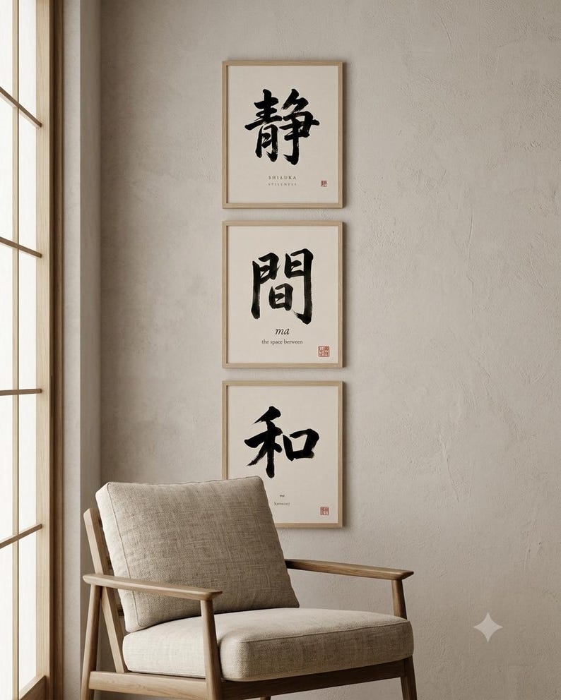 Op de afbeelding: Drie vierkante ingelijste kunstwerken verticaal gerangschikt, elk met zwarte Japanse kalligrafie op een cr&egrave;mekleurige achtergrond. De bovenste print toont het teken voor stilte, de middelste voor de tussenruimte en de onderste voor harmonie.