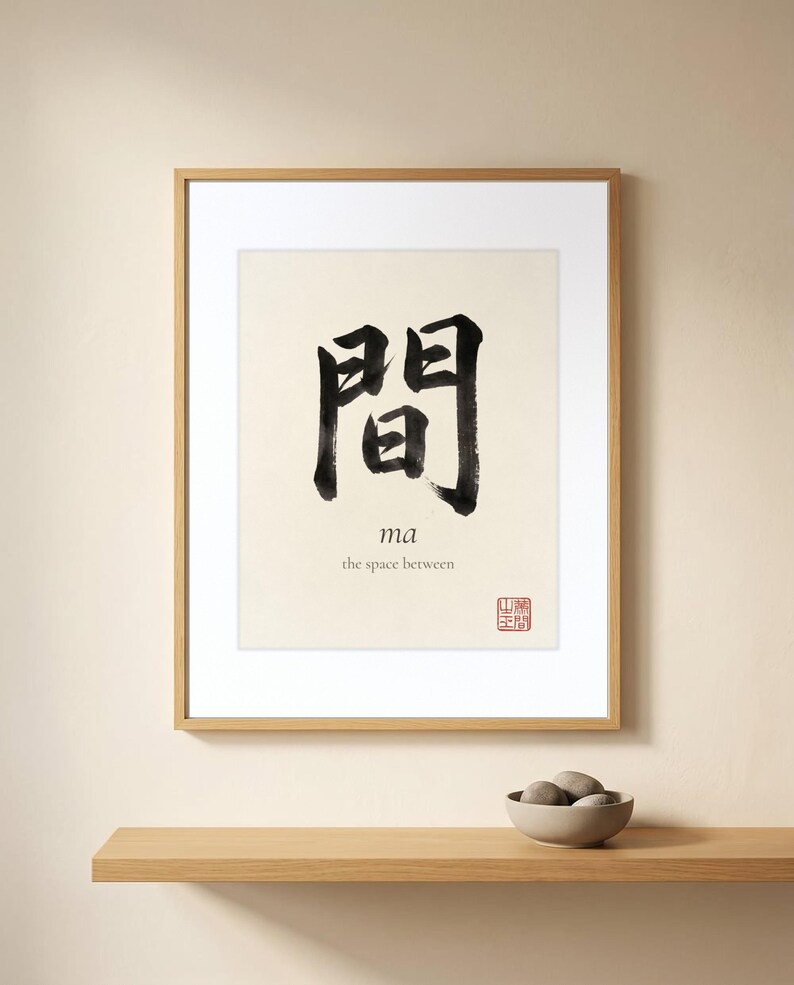 Framed "Ma" calligraphy artwork in a bright neutral living room featuring clean, modern minimalist decor.