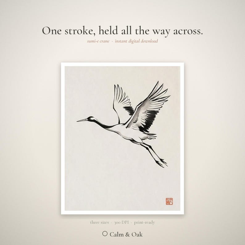 Sumi-e crane print framed in oak, seen on three quiet walls — above a linen bed, on a gallery wall and above an oak console.