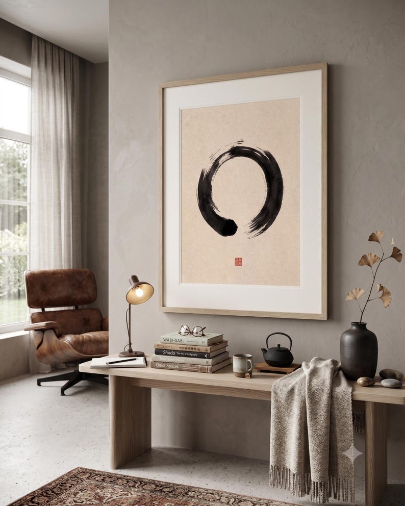 Framed Sumi Enso print displayed above a modern console table in a Japandi-inspired living room with neutral decor.