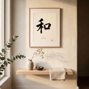 Puede incluir: Una l&aacute;mina de arte enmarcada que presenta el car&aacute;cter kanji japon&eacute;s negro para la armon&iacute;a, con la palabra inglesa harmony impresa debajo en una fuente peque&ntilde;a. La obra est&aacute; en un marco de madera clara y expuesta en una pared.