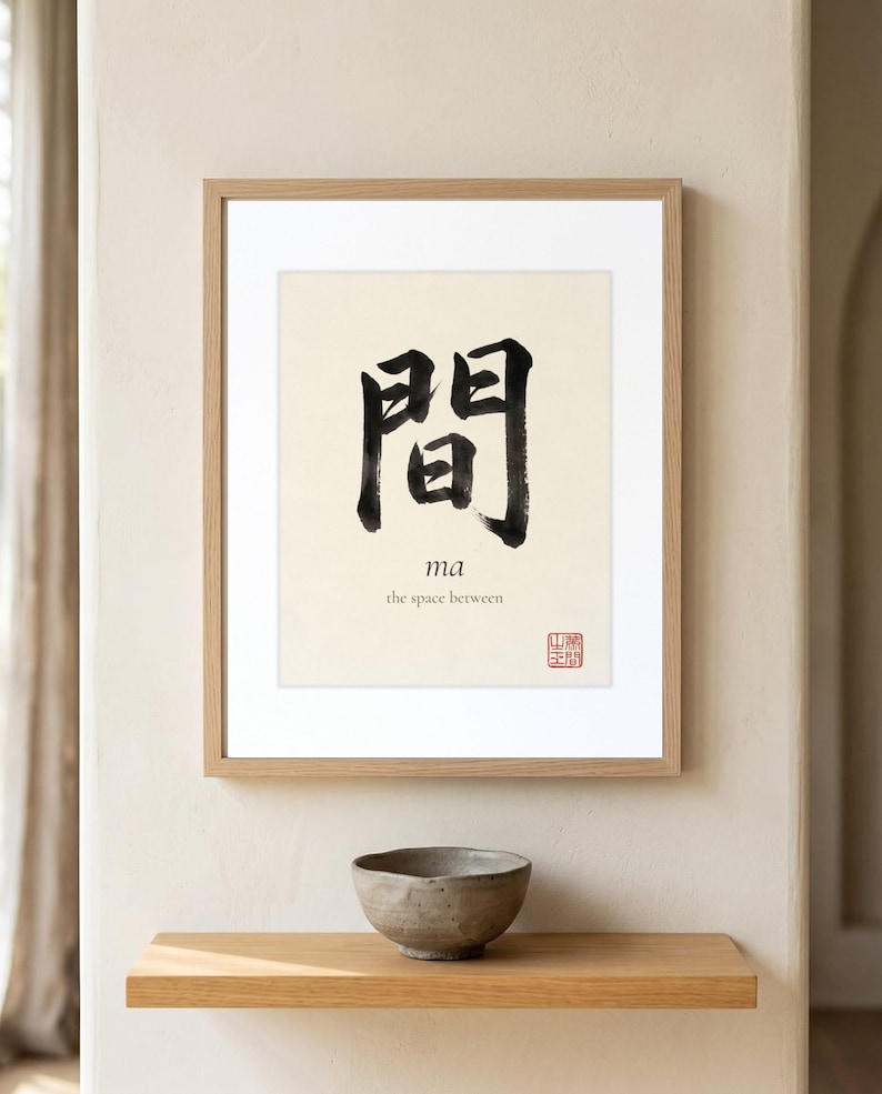 Framed "Ma" calligraphy artwork in a bright neutral living room featuring clean, modern minimalist decor.