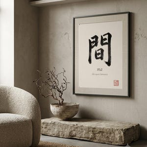 Framed "Ma" calligraphy artwork in a bright neutral living room featuring clean, modern minimalist decor.