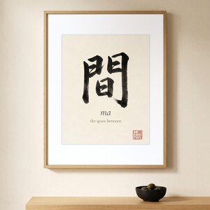 Framed "Ma" calligraphy artwork in a bright neutral living room featuring clean, modern minimalist decor.