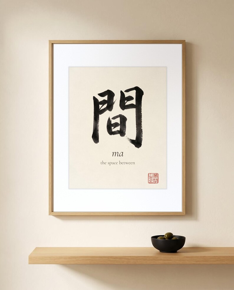 Framed "Ma" calligraphy artwork in a bright neutral living room featuring clean, modern minimalist decor.