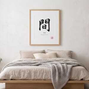 Framed "Ma" calligraphy artwork in a bright neutral living room featuring clean, modern minimalist decor.