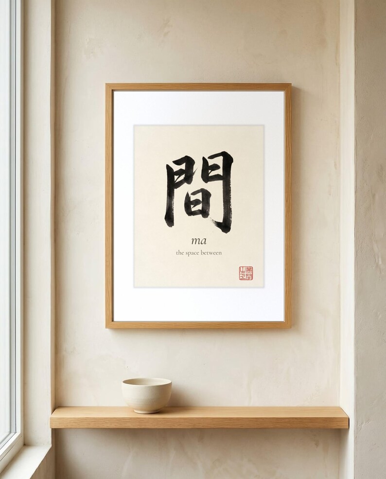 Framed "Ma" calligraphy artwork in a bright neutral living room featuring clean, modern minimalist decor.