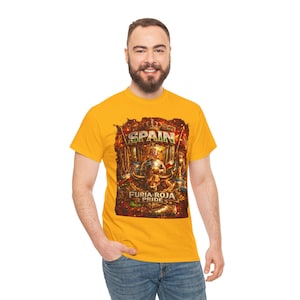 May include: A bright yellow short-sleeve t-shirt featuring a central graphic print with the text "SPAIN" and "FURIA ROJA PRIDE". The design includes a bull, a soccer ball, a crown, and fiery orange and red accents on the front of the garment.