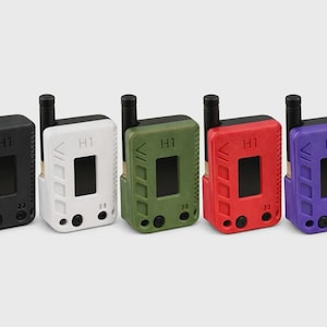 May include: Five rectangular electronic devices arranged in a row, coloured black, white, olive green, red, and purple. Each device features a black antenna, a central screen, the text H1, and three circular buttons on the front face.