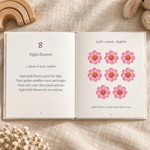 An open counting book shows the number 8, the Eight flowers rhyme and Sophie's name on the left. Exactly eight pink flowers appear on the right, with a prompt to count each bloom once.