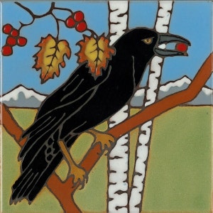 May include: A black crow with a red berry in its beak perched on a branch with yellow leaves. The crow is in front of a white birch tree with a green and brown background.