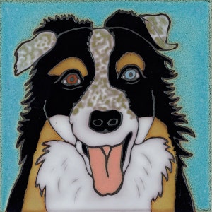 Può includere: Un cane pastore australiano nero, bianco e marrone con occhi blu e marroni. Il cane sta sorridendo con la lingua di fuori. Il cane è dipinto su uno sfondo blu.