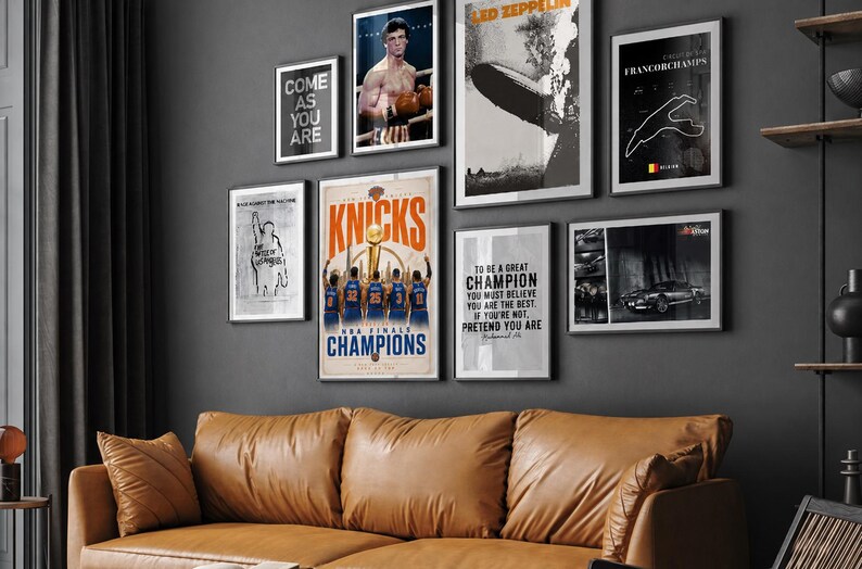 Pode incluir: Uma parede de galeria com oito cartazes emoldurados com temas diversos, incluindo um campeonato de basquete, uma luta de boxe, uma banda de rock, um mapa de circuito de corrida, um carro cl&aacute;ssico e cita&ccedil;&otilde;es motivacionais em texto preto e branco.