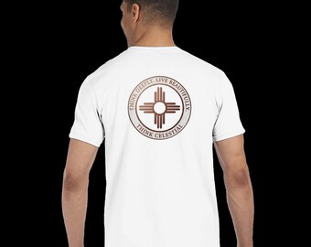 Puede incluir: Una camiseta blanca de manga corta con un gráfico circular en la espalda. El diseño incluye un símbolo solar Zia marrón centrado dentro de un anillo que contiene el texto THINK DEEPLY, LIVE BEAUTIFULLY, THINK CELESTIAL en fuente marrón oscuro.