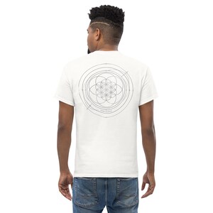 Könnte beinhalten: Ein weißes kurzärmeliges T-Shirt mit einer dünnen, dunkelgrauen Linien-Grafik auf der Rückseite. Das Design besteht aus einem zentralen Blume-des-Lebens-Muster, umgeben von konzentrischen Kreisen und Orbitallinien, mit dem Text "ORBIT CELESTIAL" darunter.