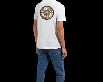 Puede incluir: Una camiseta blanca de manga corta con un gráfico circular en la espalda. El diseño incluye una ilustración de un sol dorado con el texto "THINK CELESTIAL" y "AS ABOVE SO BELOW" impreso en un borde circular oscuro alrededor del sol.
