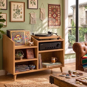 Può includere: Un mobile multimediale in legno di rovere chiaro con un giradischi sulla parte superiore, un ricevitore audio nero e diversi ripiani aperti contenenti dischi in vinile, libri, un terrario in vetro geometrico e vari oggetti decorativi.