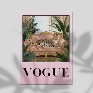 May include: A rectangular wall art print featuring a leopard wearing a gold crown, resting on a pink tufted sofa with gold trim. The scene is surrounded by green tropical plants. The word VOGUE is printed in large black capital letters below.