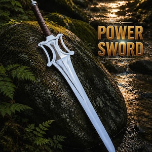 May include: A silver-colored sword with a brown wrapped handle and a distinctively shaped guard. The blade features a central ridge and tapers to a point. Text on the image reads POWER SWORD and INSPIRED BY HE-MAN in blue and red lettering.
