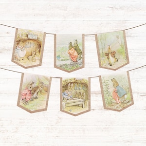 Puede incluir: Una pancarta decorativa con seis banderines con ilustraciones de conejos en varias escenas. Los banderines son rectangulares con un borde de arpillera y están unidos por una cuerda marrón. Las ilustraciones son en colores pastel suaves.