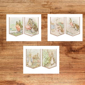 May include: Three sets of illustrated banner flags featuring scenes with rabbits in a vintage style. The illustrations depict rabbits in various settings, with soft colors and a classic storybook aesthetic. The banners have a decorative border.