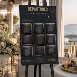 May include: A dark charcoal wedding seating chart sign on an easel with gold text reading DEPARTURES and FIND YOUR DESTINATION. It features nine rectangular panels labeled with city names like Paris and Bali, listing guest names in a grid format.