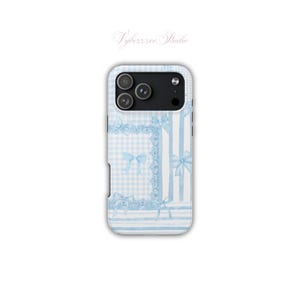May include: A smartphone case featuring a light blue and white gingham pattern, vertical stripes, and decorative lace-trimmed frames with bow accents. The design includes the text Vybezzzee Studio at the top and a black camera lens cutout.