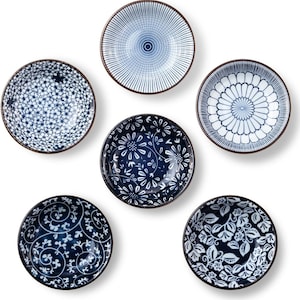 May include: A set of five round ceramic bowls arranged in a cluster. Each bowl features a distinct blue and white pattern, including floral, petal, and geometric line designs. The bowls have a dark brown rim and a smooth, glossy finish.