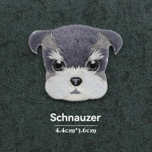 Puede incluir: Un parche bordado que muestra la cabeza de un perro Schnauzer con detalles en hilo gris y blanco. El parche tiene una parte superior gris oscuro y un hocico blanco. Debajo de la cabeza del perro, el texto dice Schnauzer y 4.4cm*3.6cm.