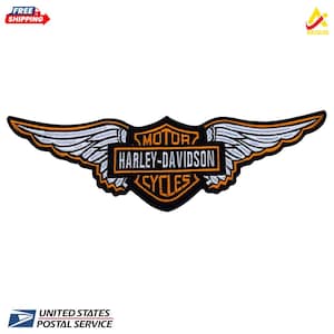 Può includere: Una toppa ricamata Harley-Davidson caratterizzata da uno scudo centrale con il testo MOTOR HARLEY-DAVIDSON CYCLES in arancione e bianco su sfondo nero, affiancato da due ali bianche stilizzate con contorni arancioni e bordi neri.