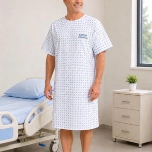 Peut inclure: Une blouse d'hôpital blanche à manches courtes avec un motif géométrique bleu répétitif. La poitrine porte l'inscription BAPTIST HOSPITAL en bleu foncé. Le vêtement a une encolure ronde et arrive aux genoux, porté avec des chaussons blancs.