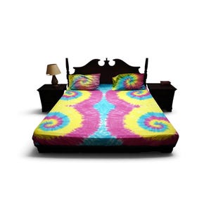 May include: A bed featuring a tie-dye pattern bed sheet and two matching pillowcases in vibrant shades of yellow, magenta, and cyan. The bed is framed by a dark wooden headboard and footboard, with two dark wooden nightstands on either side.