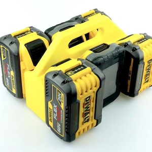May include: A yellow plastic battery storage mount holding four DeWalt FlexVolt 60V lithium-ion batteries. The batteries are black and yellow with clear labels indicating 60V and 20V compatibility, featuring a 9.0Ah capacity rating on the side.