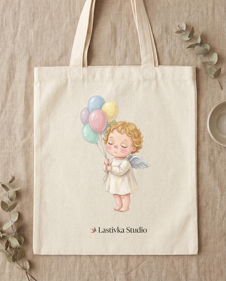 Pode incluir: Uma sacola de lona na cor creme com uma ilustra&ccedil;&atilde;o impressa de um pequeno anjo de cabelos loiros cacheados e asas brancas, segurando um grupo de bal&otilde;es em tons pastel. O texto Lastivka Studio est&aacute; impresso em preto abaixo do anjo.