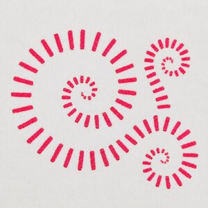 May include: A white fabric surface featuring three embroidered spiral designs in bright pink thread. Each spiral is composed of individual, short, straight stitches arranged in a circular pattern that radiates outward from a central point.